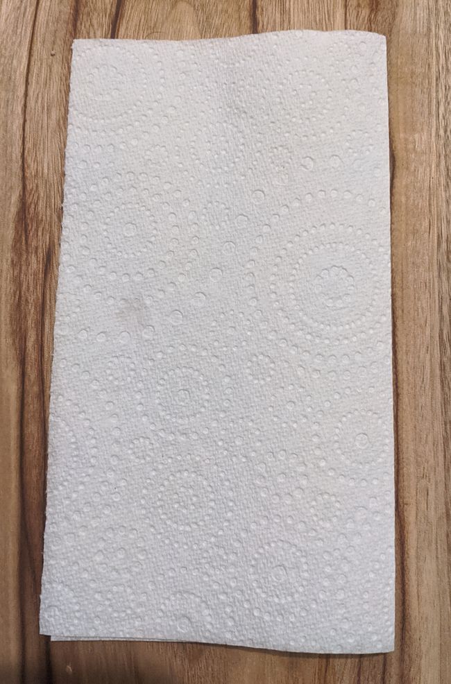 Start by folding a paper towel segment in half